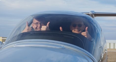 Men give thumbs up on the plane